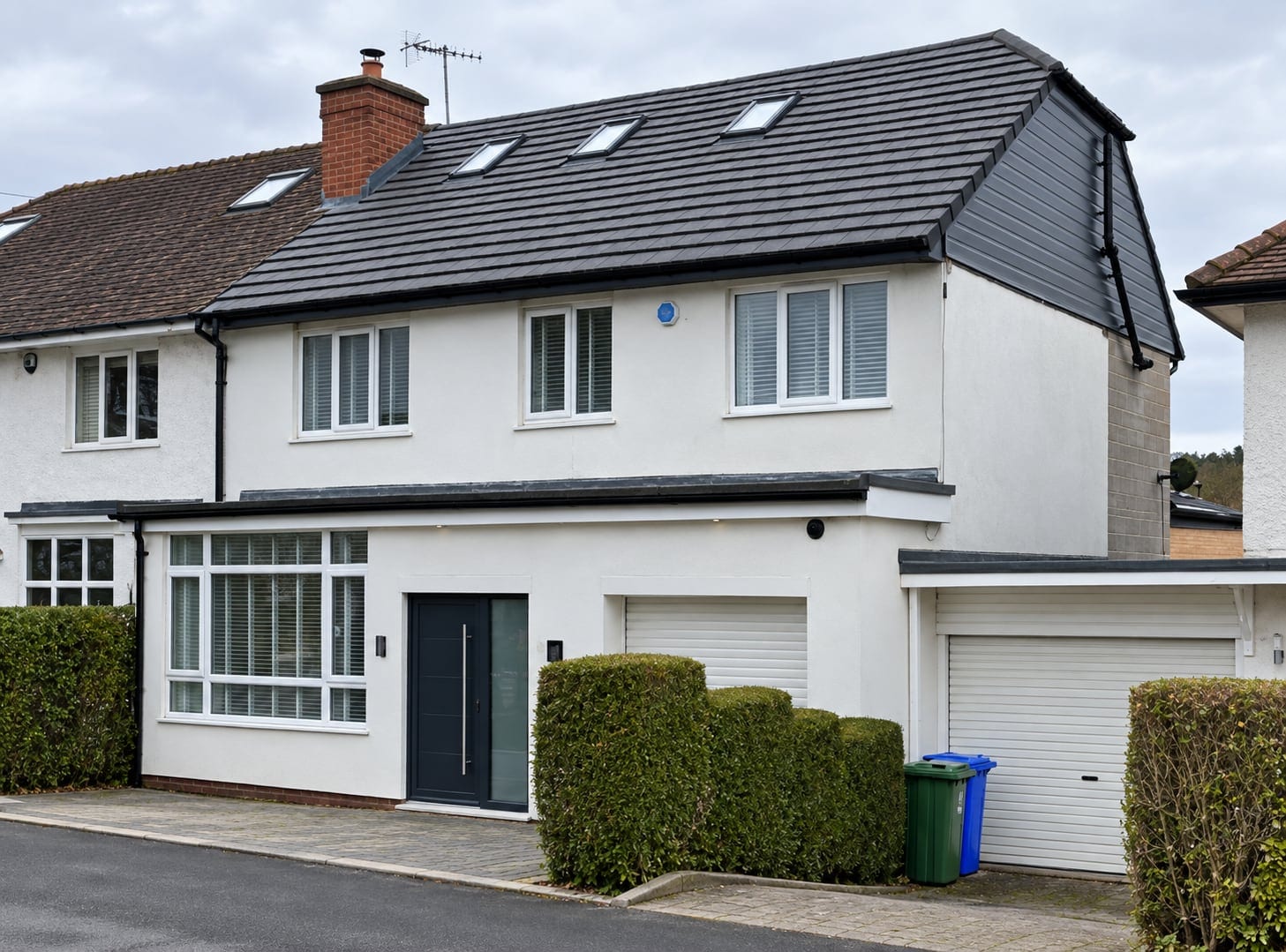 Front of the white-rendered house with rooflights in the new roof
