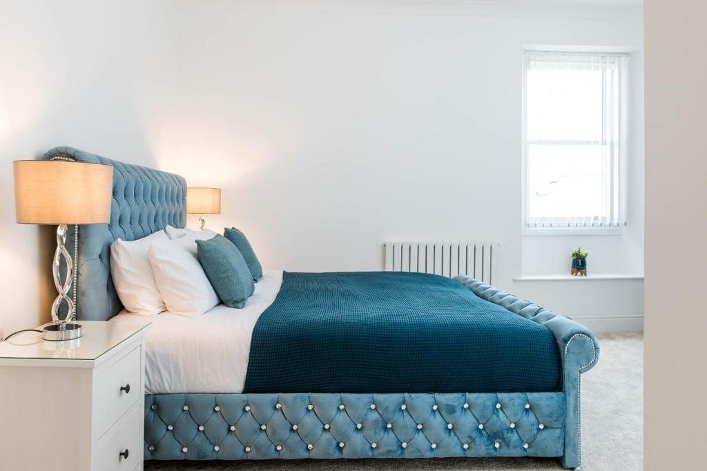 Main bedroom with a blue upholstered bed