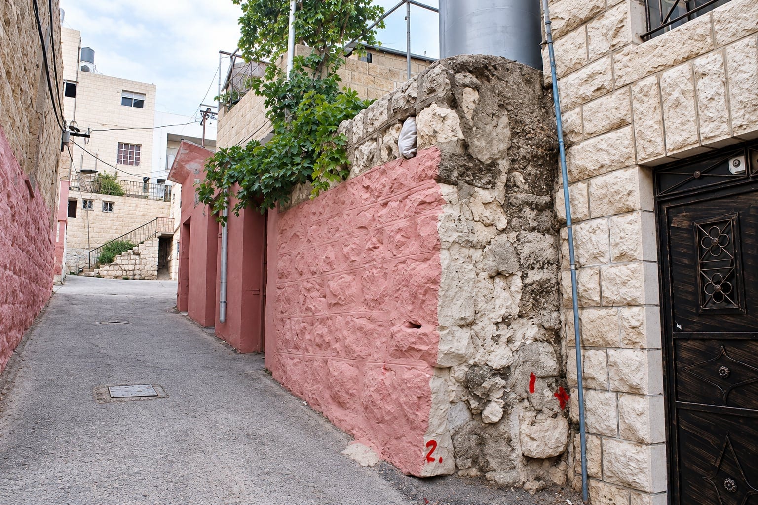 Narrow street in Hebron with stone and rendered walls