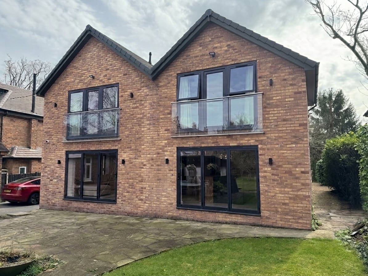 Rear of the house: two brick gables with Juliet balconies and wide glazed doors