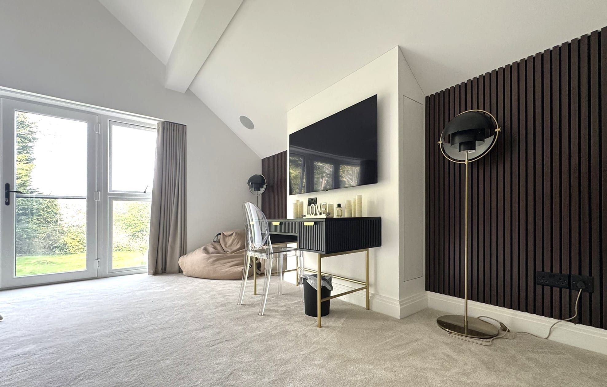 Main bedroom with tall windows and a slatted timber wall