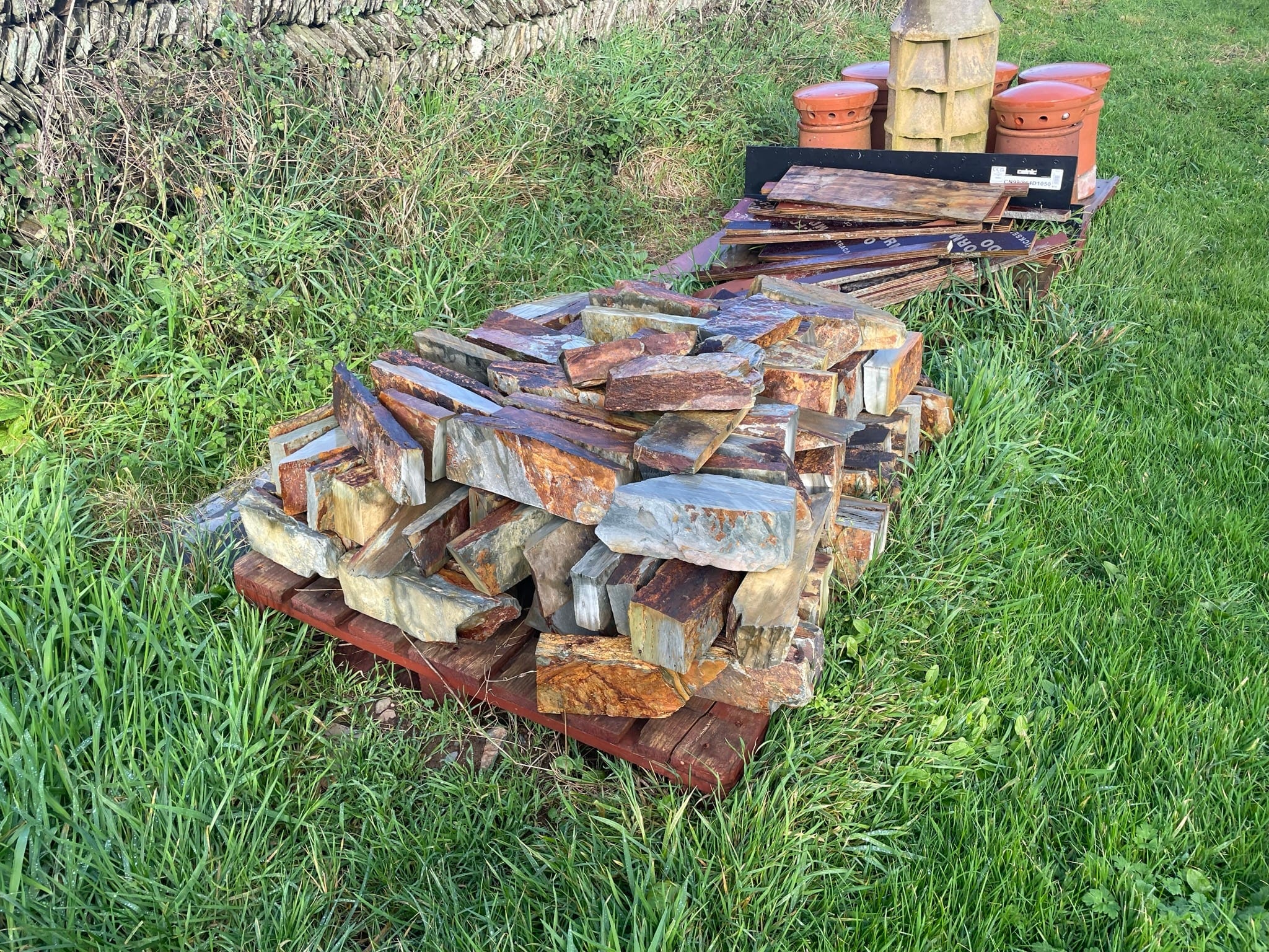 A pallet of reclaimed local stone on the grass