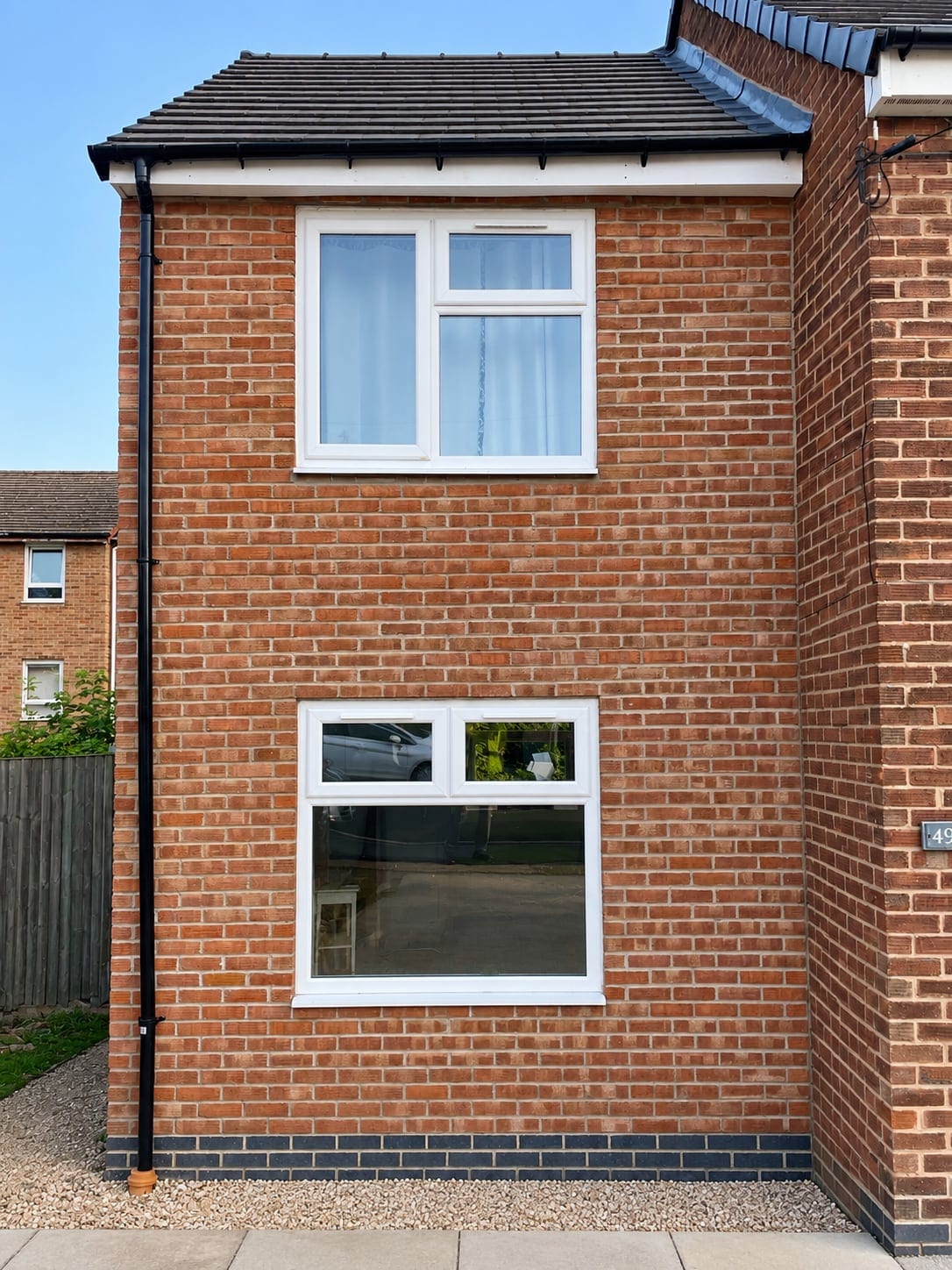 Two-storey red-brick side extension with white windows
