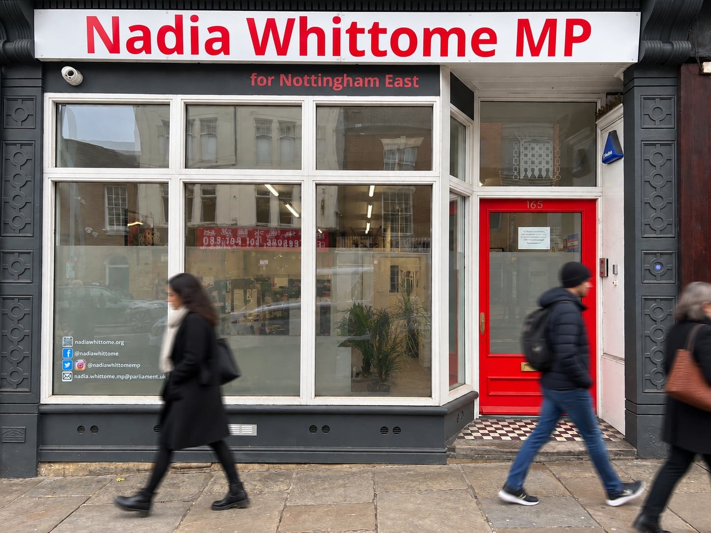 Constituency office shopfront with a red door, people passing on the pavement