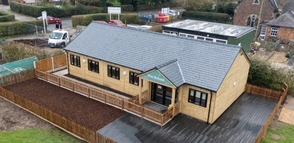 Single-storey nursery building with a timber-fenced garden