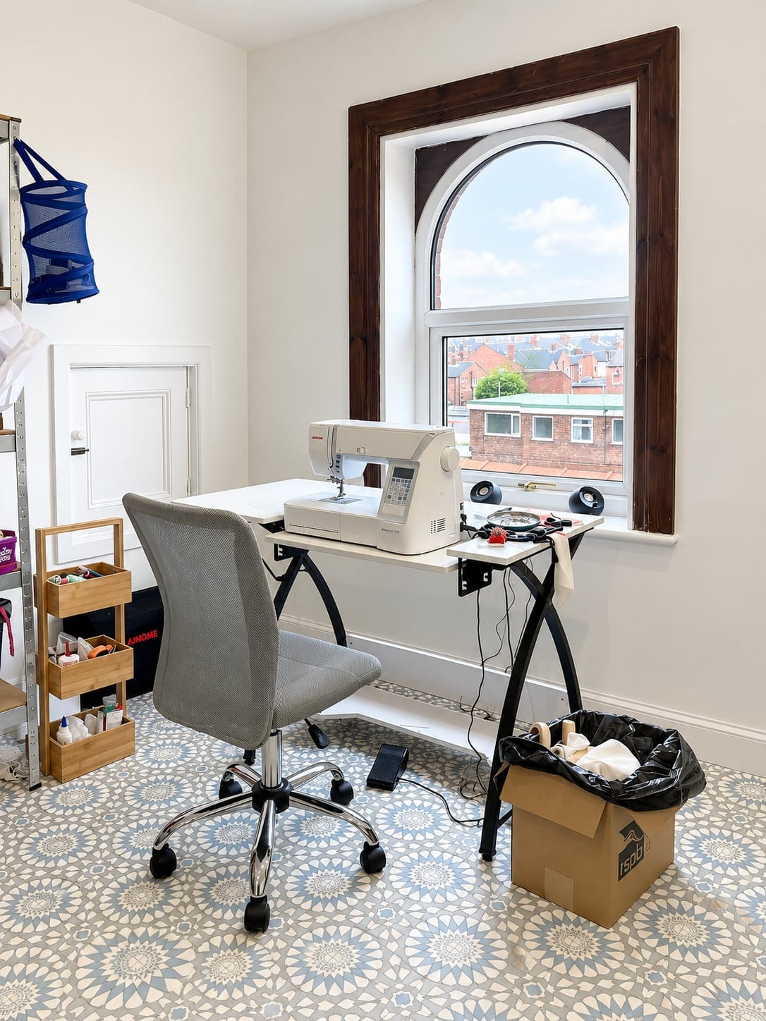 Sewing workspace beside the arched window, seen at an angle
