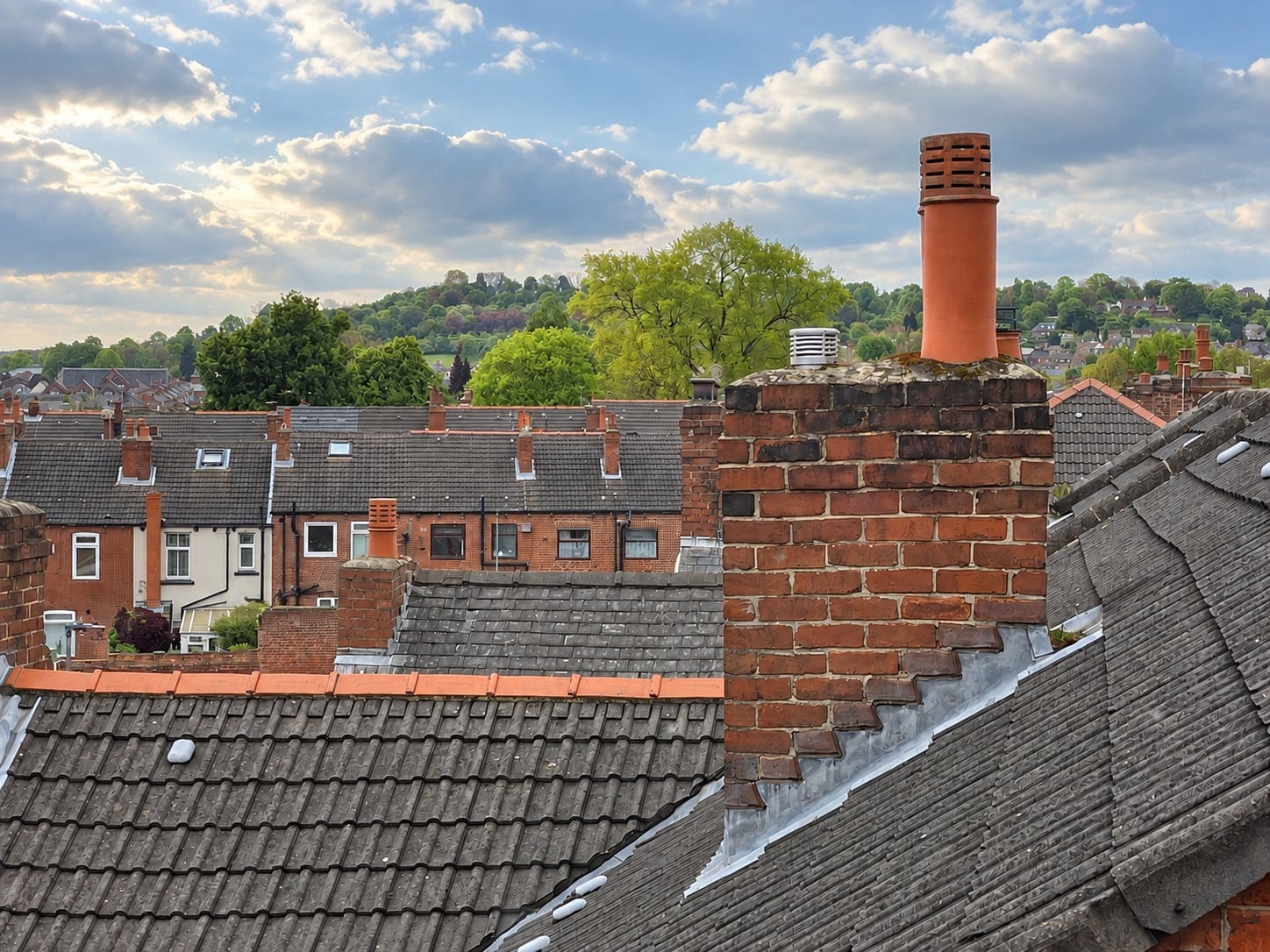View from the arched window across chimneys and rooftops to the hills