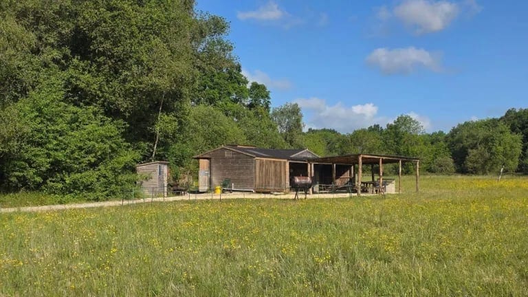 Campers' kitchen building in a wildflower meadow